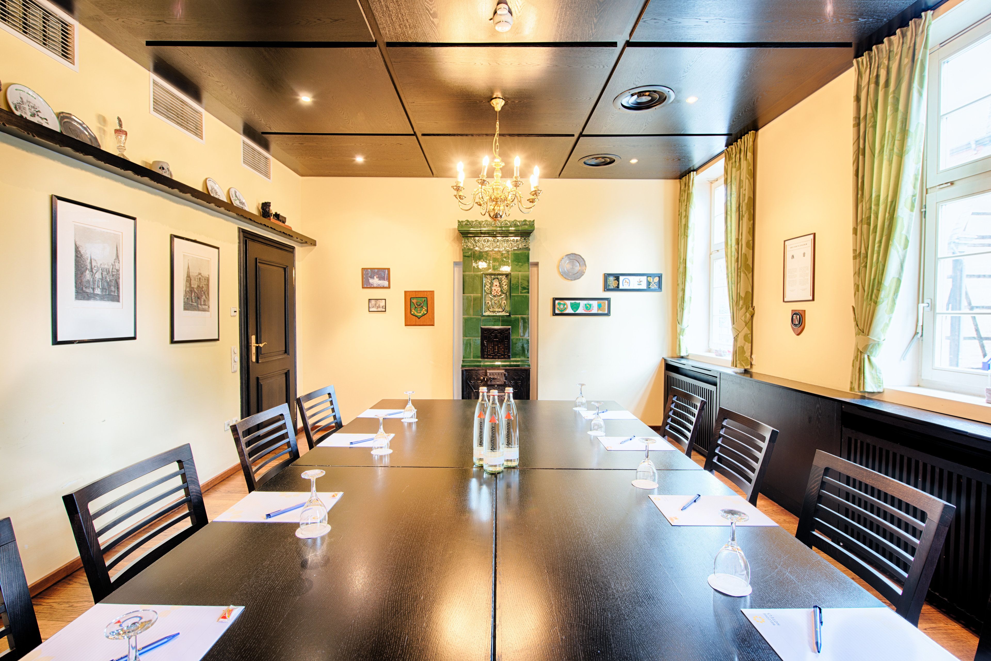 A conference room with a long table, chairs, and a chandelier.