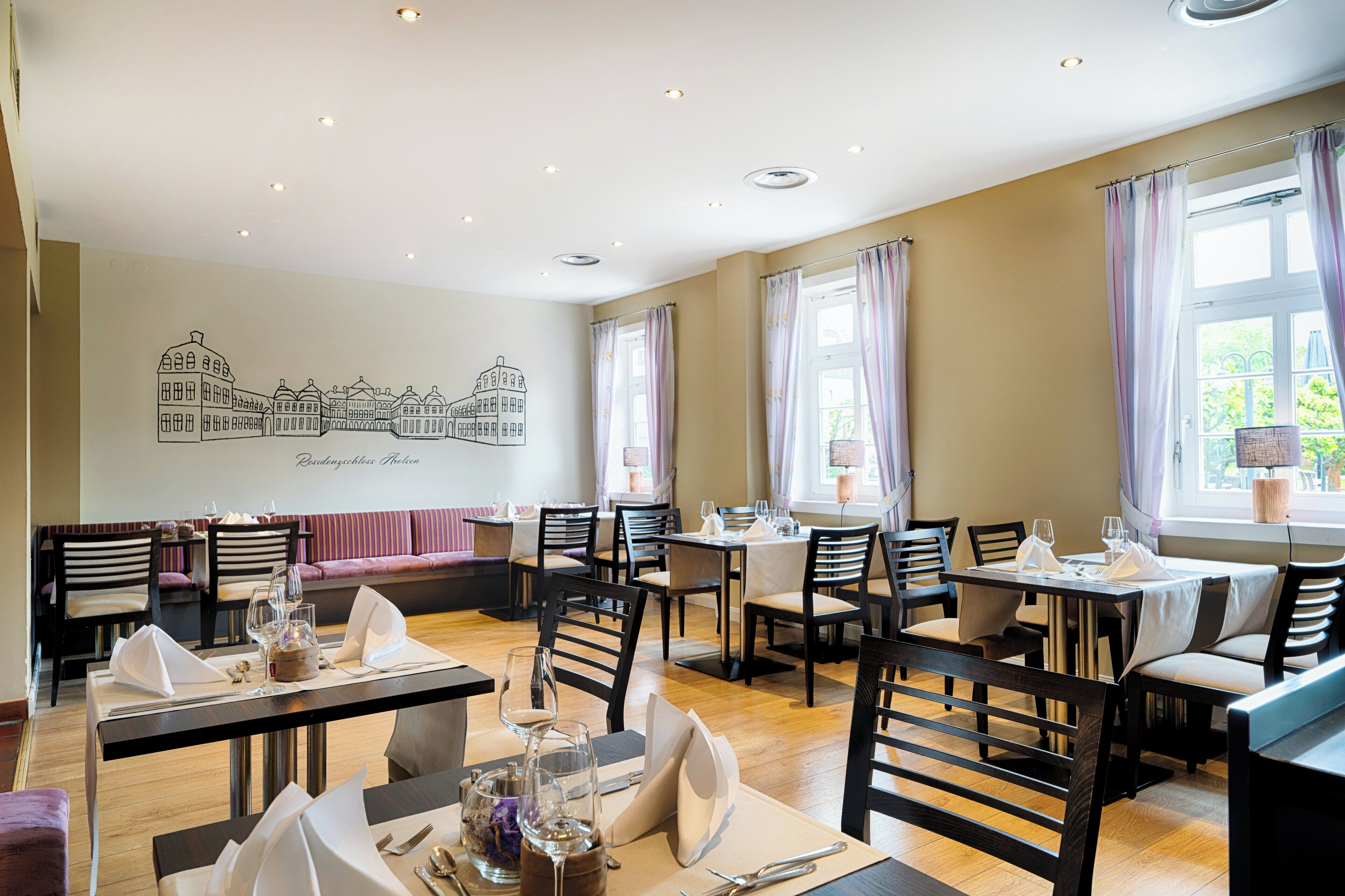 A restaurant with multiple dining tables, chairs, and a mural of buildings on the wall.