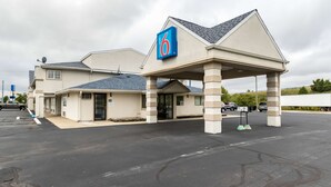A motel with a '6' sign, a covered entrance, and a parking lot. - Motel 6 Crawfordsville, IN (Crawfordsville)