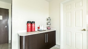 A kitchen area with a white countertop, dark cabinets, and a white door. - Motel 6 Crawfordsville, IN (Crawfordsville)