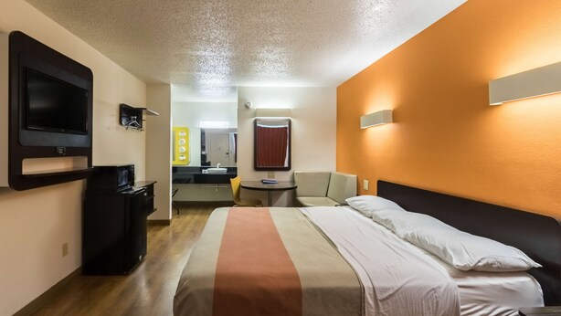 A hotel room with a bed, a TV, a desk, and a chair. - Motel 6 Crawfordsville, IN (Crawfordsville)