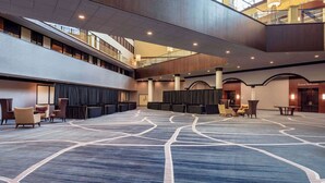 A spacious lobby with a high ceiling, a Grand Ballroom, and a seating area with chairs and tables. - Sonesta Hotel Houston IAH Airport (Houston)