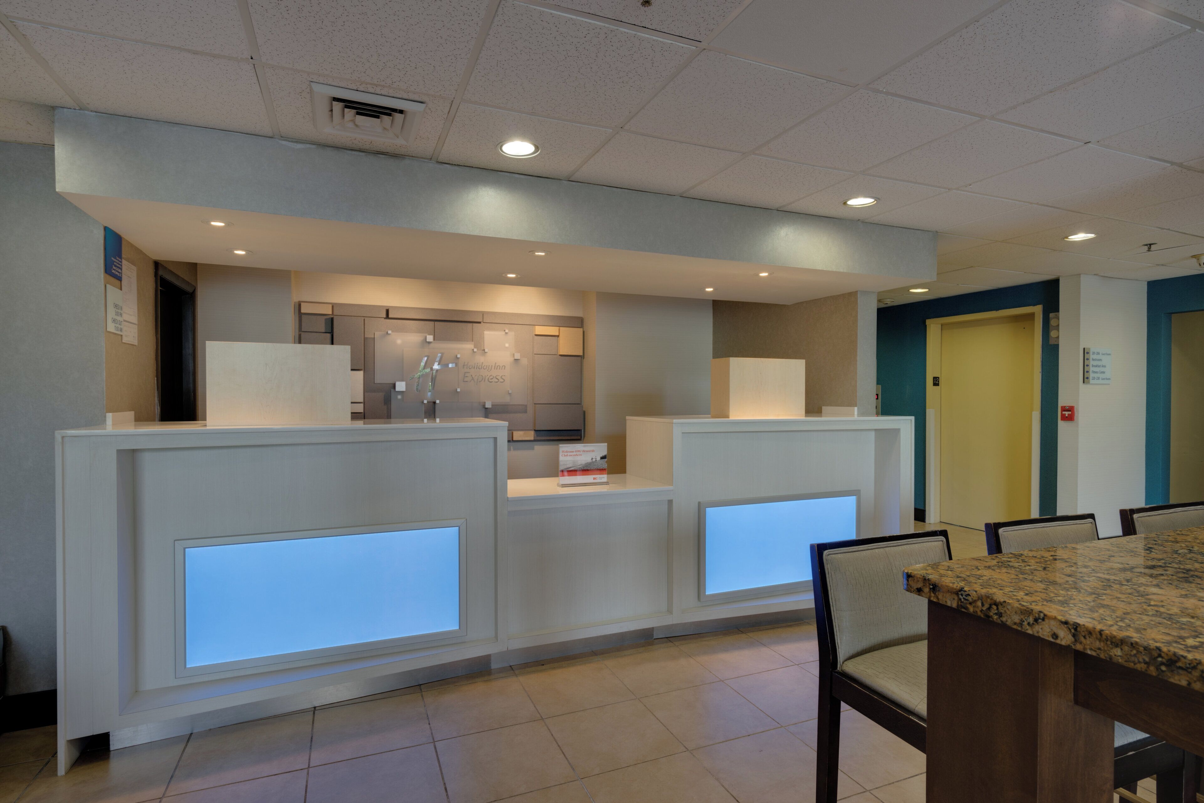 A reception area with a counter, chairs, and a tiled floor.