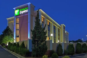 Un hotel Holiday Inn Express con fachada moderna, múltiples ventanas y una entrada bien iluminada.