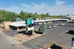 A parking lot with a hotel named 'Quality Inn' and 'Suburban Extended Stay Hotel' signs. - Suburban Studios near Mesa Verde (Cortez)