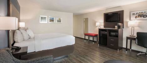 A hotel room with a bed, a desk, a TV, and a chair.