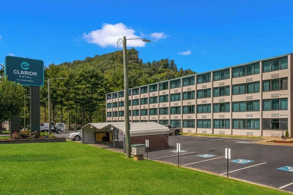 Un hôtel doté d’un parking, d’un espace d’attente abrité et d’un bâtiment à plusieurs étages avec de grandes fenêtres.
