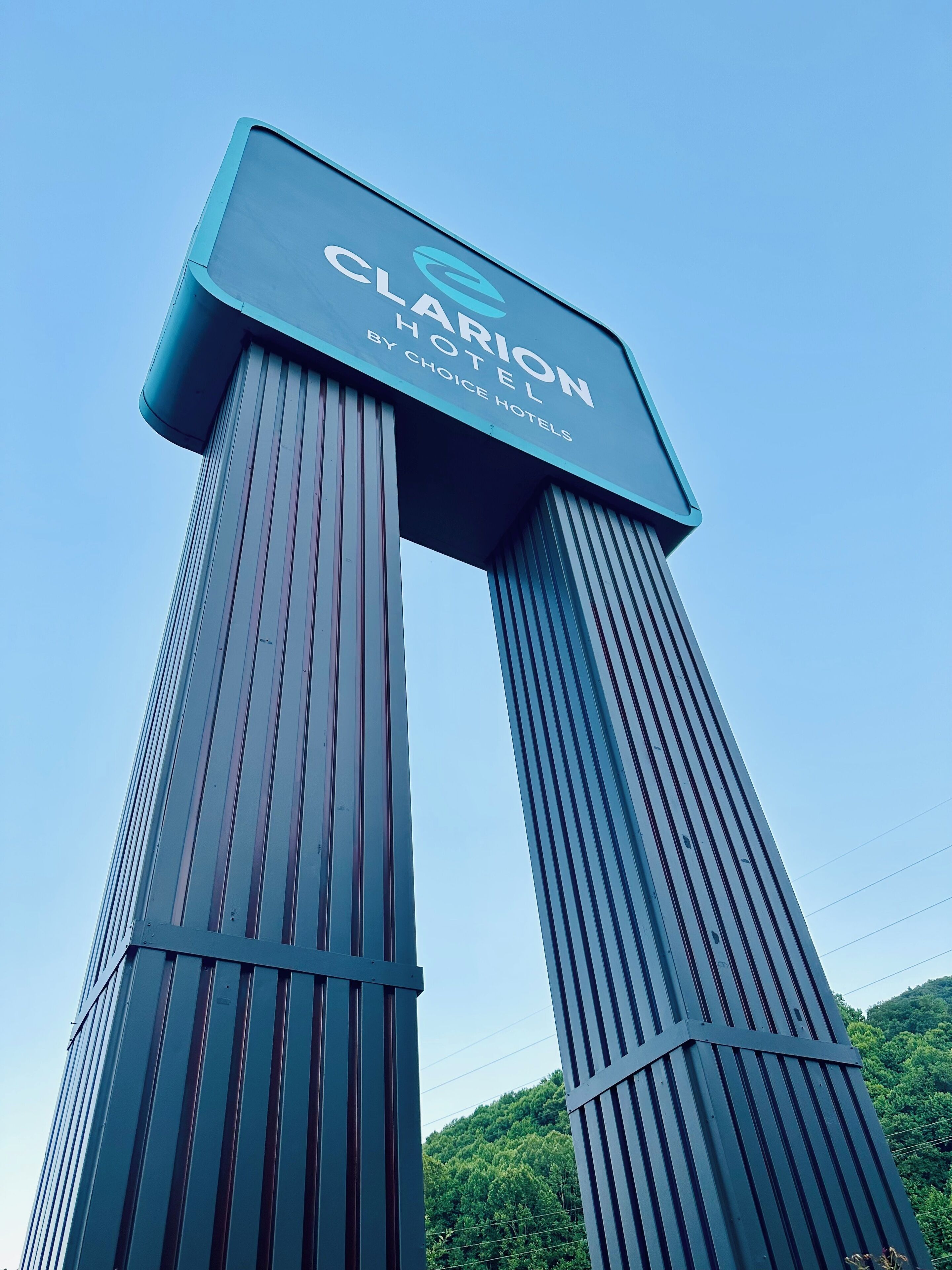 A tall, modern hotel sign with the name 'Clarion Hotel by Choice Hotels'.