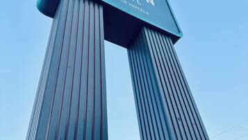 A tall, modern hotel sign with the name 'Clarion Hotel by Choice Hotels'.