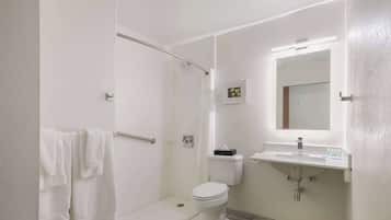Un baño moderno con cabina de ducha, inodoro y lavamanos.