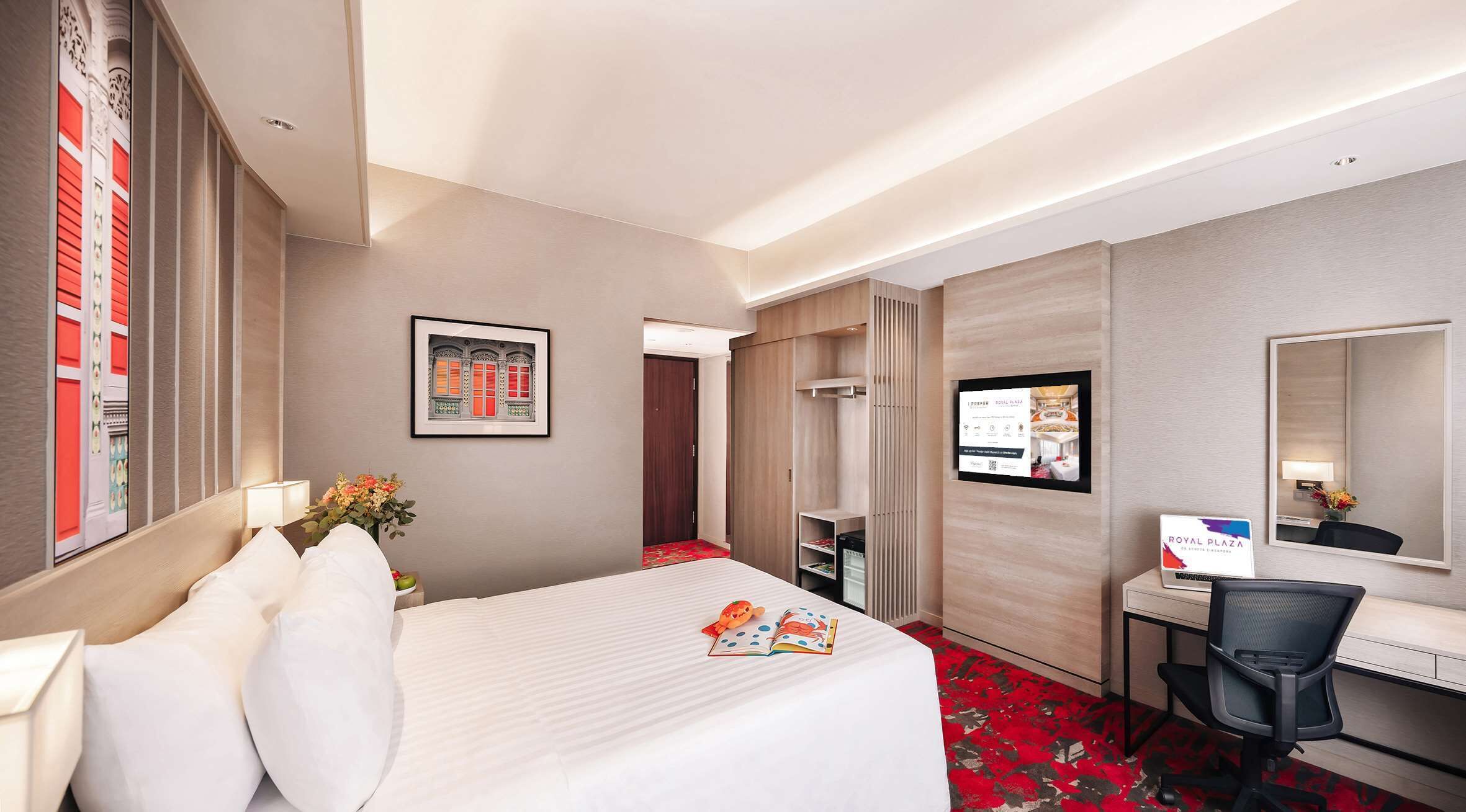 Habitación de hotel con cama, escritorio, silla y un cuadro en la pared.
