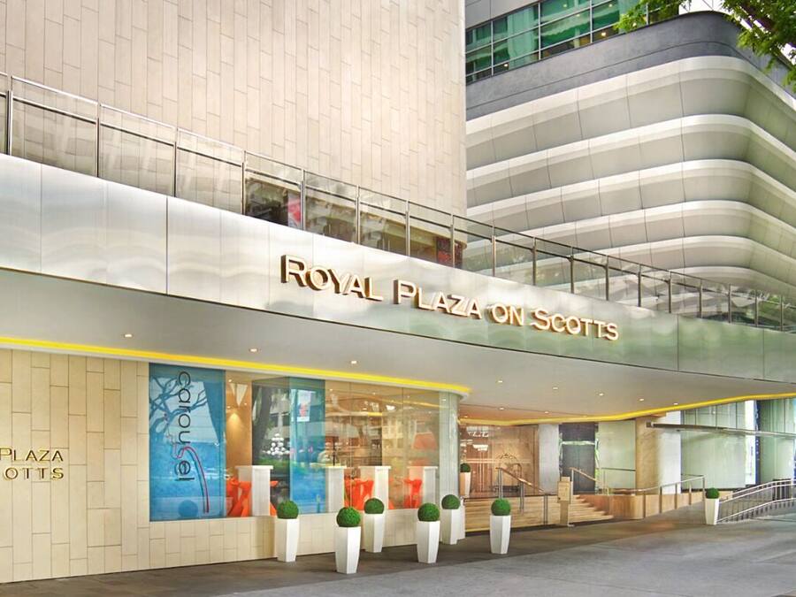 Het uiterlijk van hotel Royal Plaza on Scotts, met een modern architectuurontwerp, grote glasramen en een opvallende entree.
