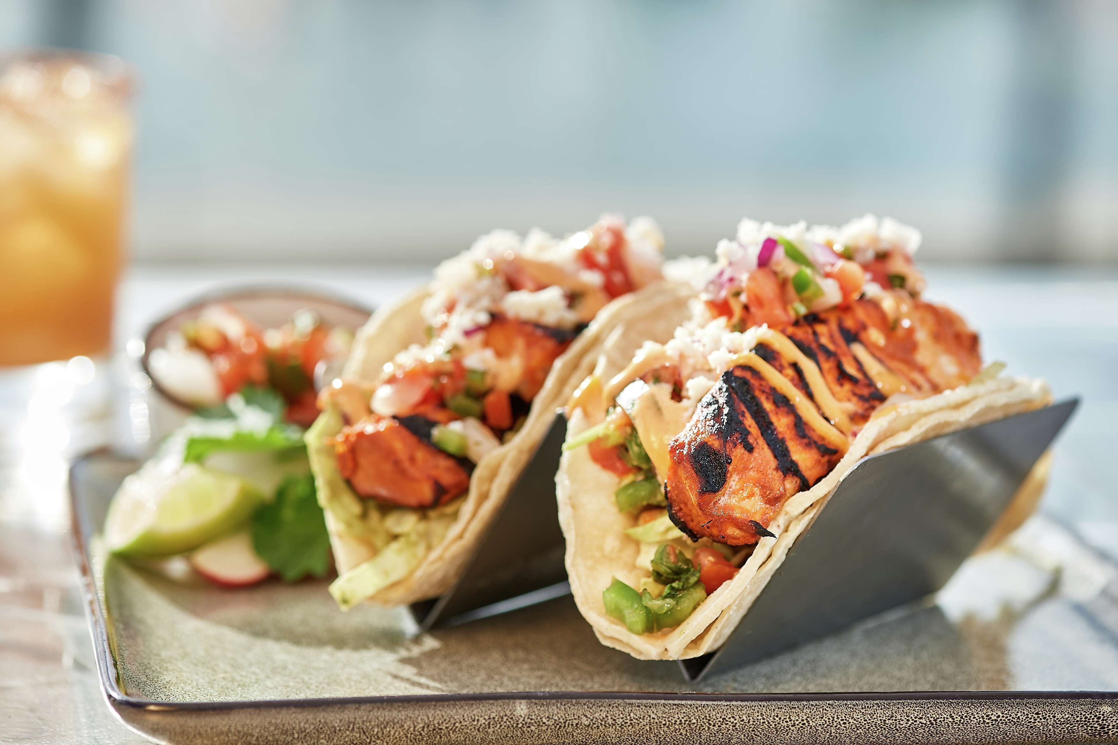 Two grilled chicken wraps on a tray.