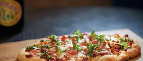 A pizza on a wooden board.