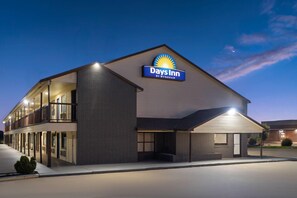 A Days Inn hotel with a flat roof, a balcony on the second floor, and a sign indicating it is by Wyndham.