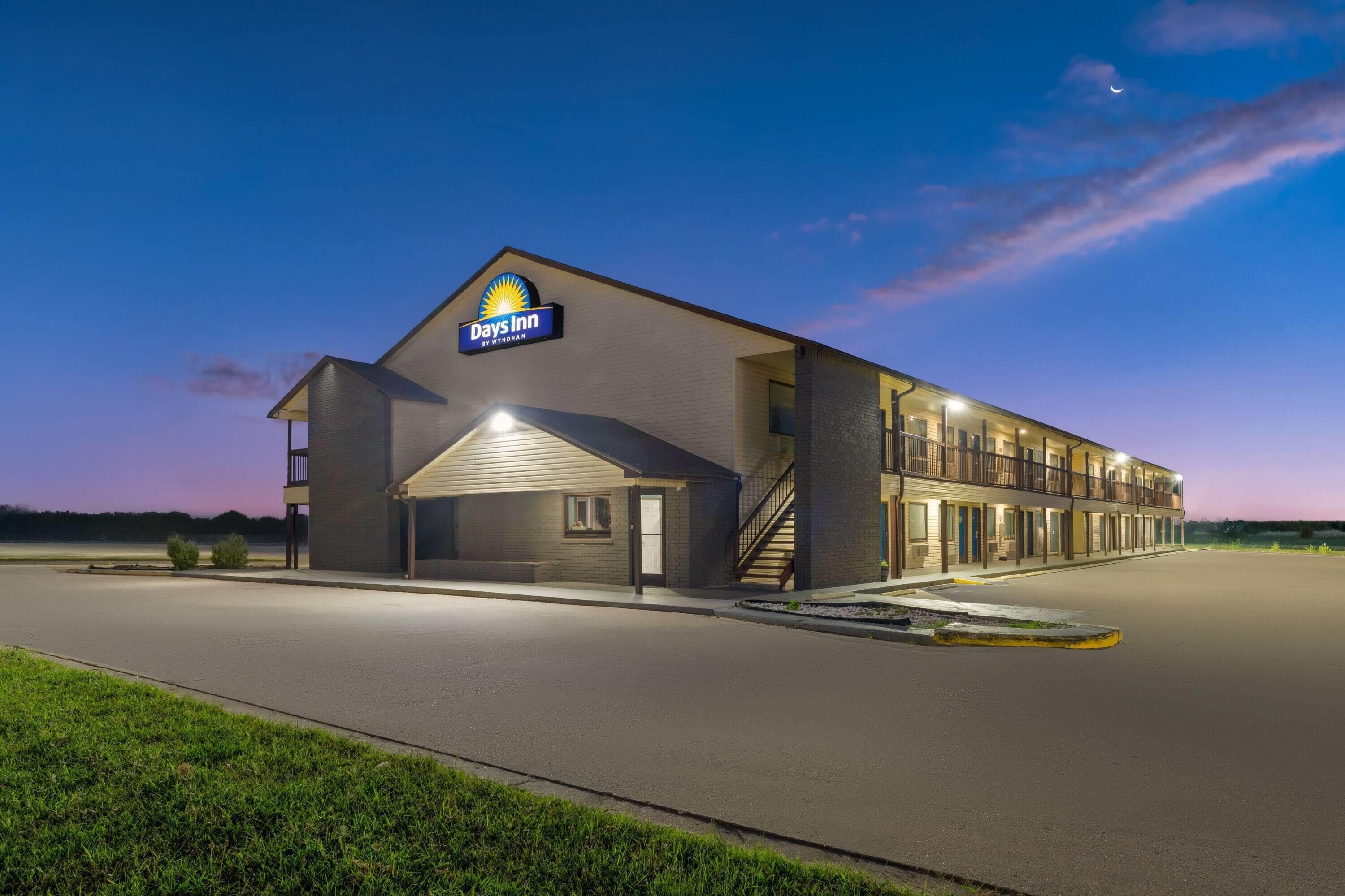 A Days Inn by Wyndham hotel with a large parking lot and a covered outdoor area.
