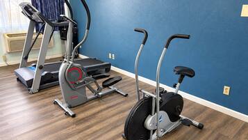Un gimnasio en casa con dos bicicletas estáticas y una cinta de correr.