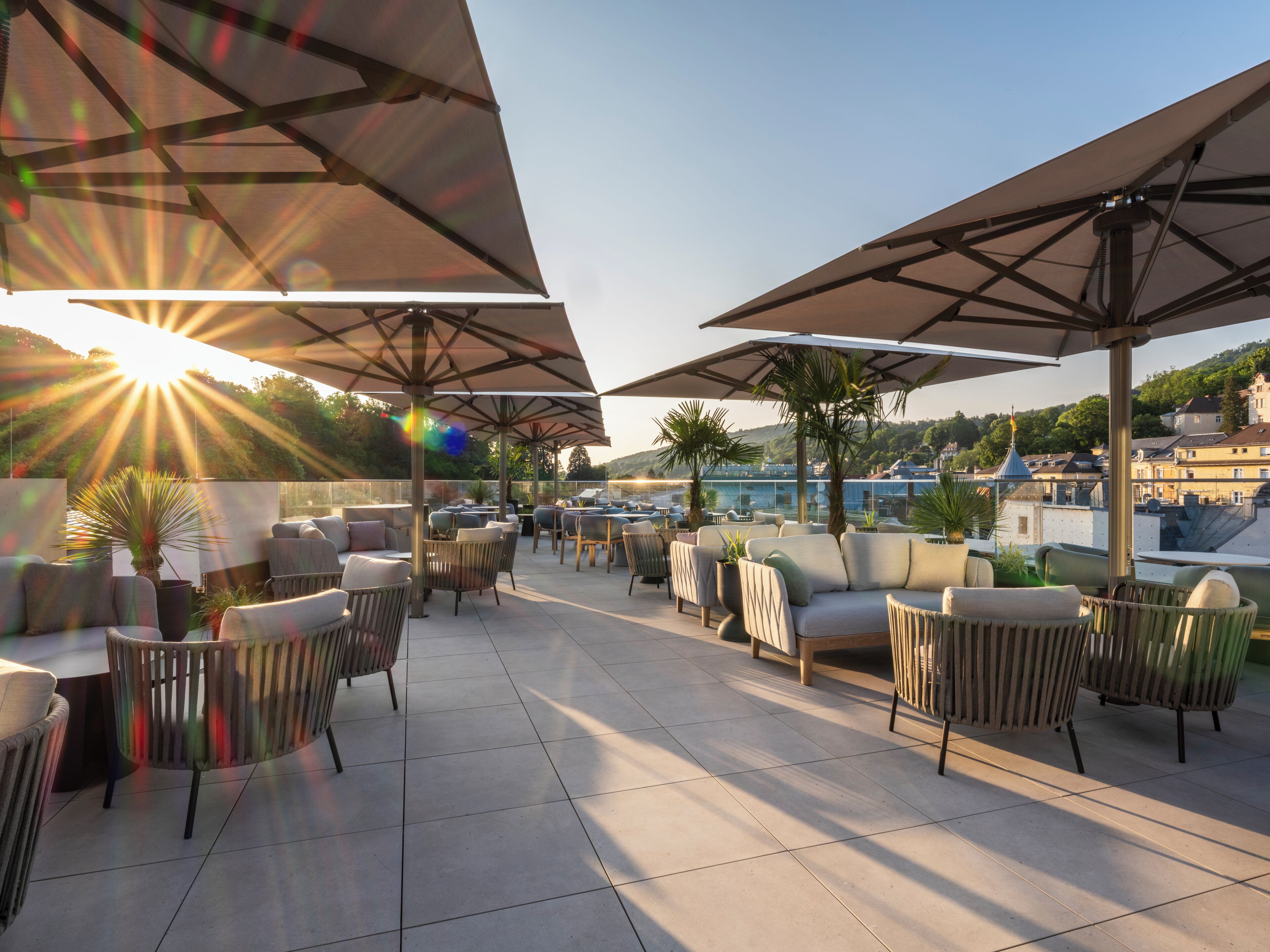 An outdoor seating area with umbrellas, chairs, and potted plants.
