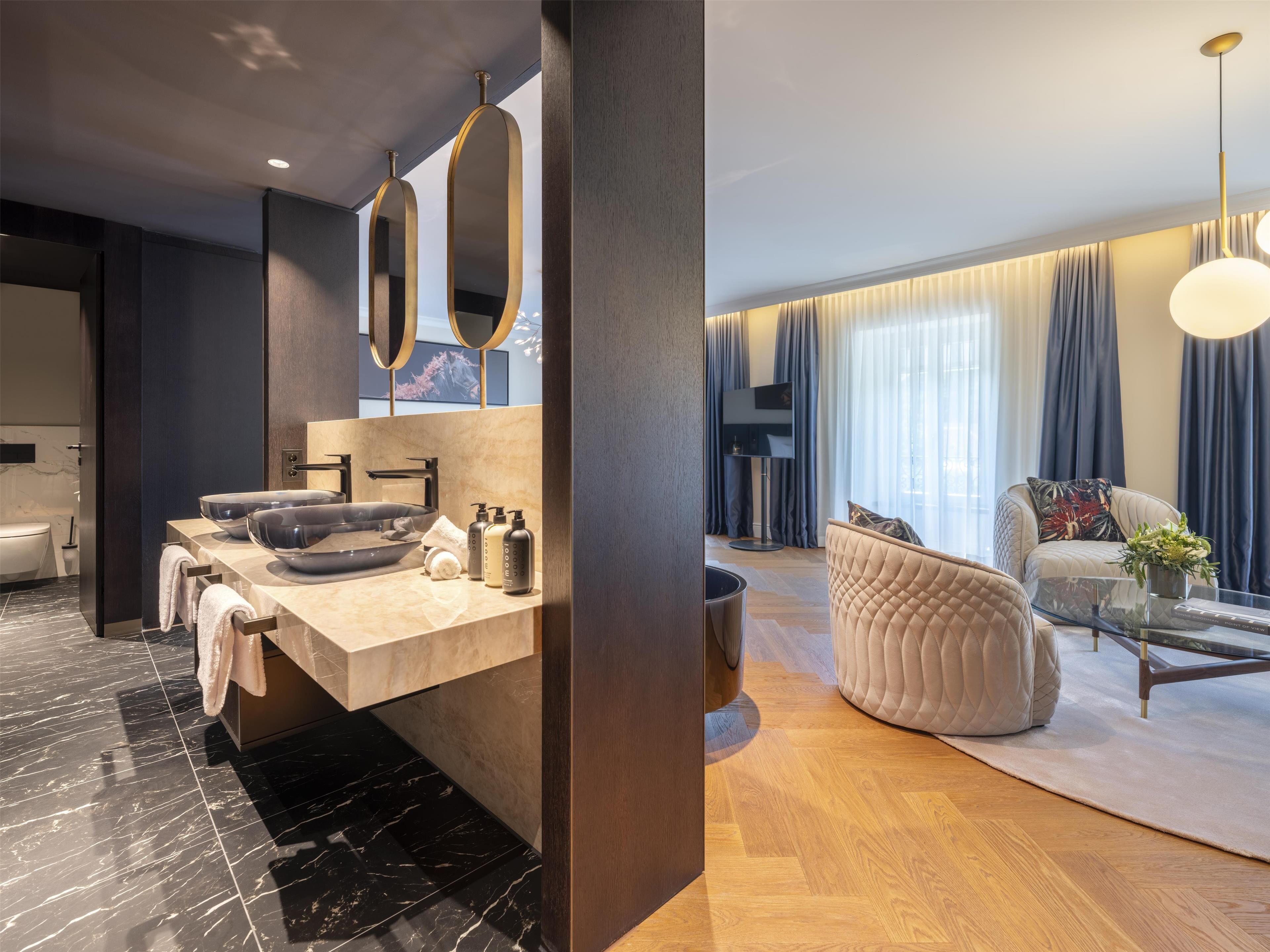 A modern bathroom with a large vanity, a bathtub, and a toilet.
