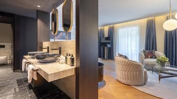 A modern bathroom with a large vanity, a bathtub, and a toilet.