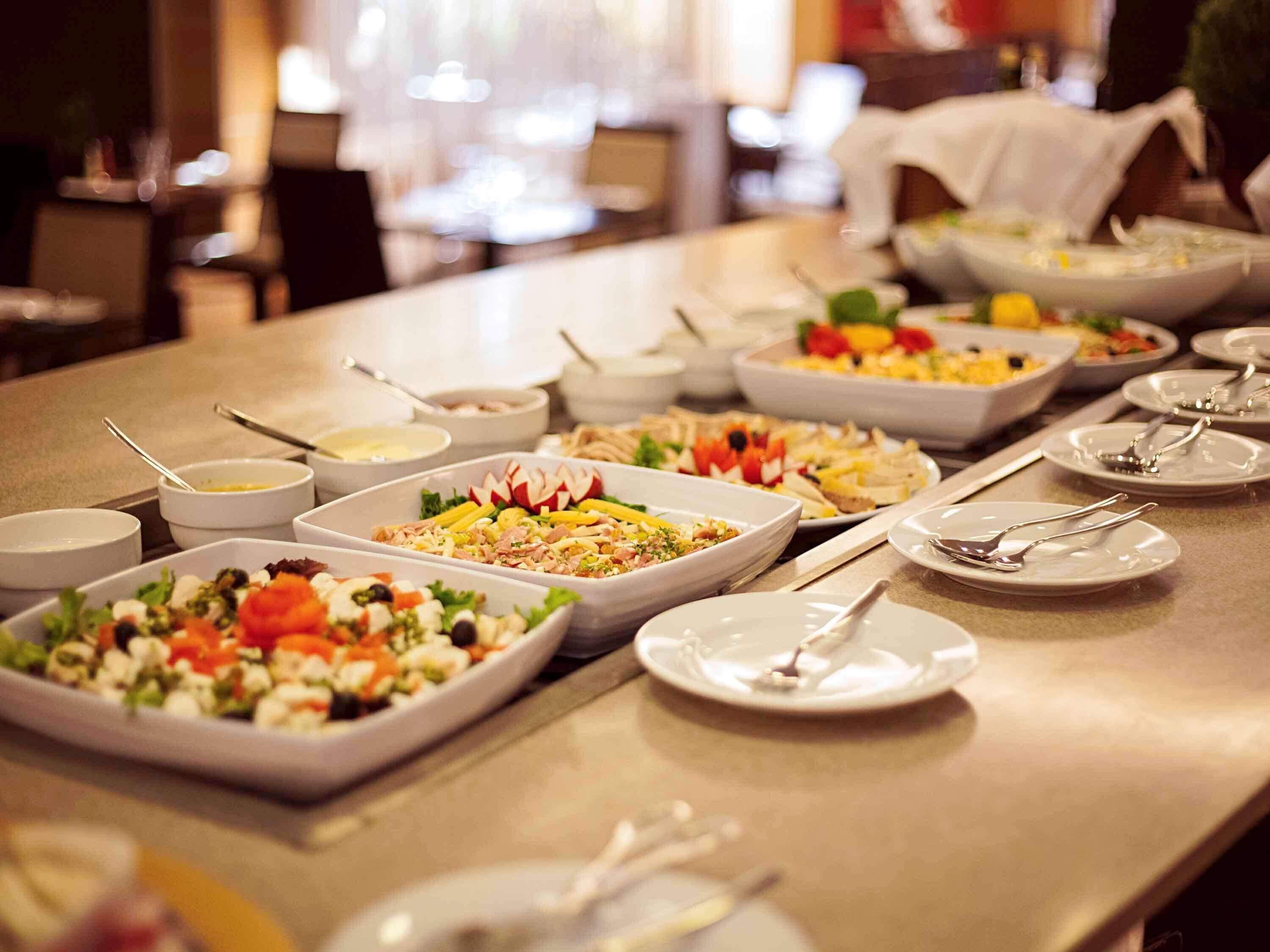 A buffet with various dishes and bowls of food.