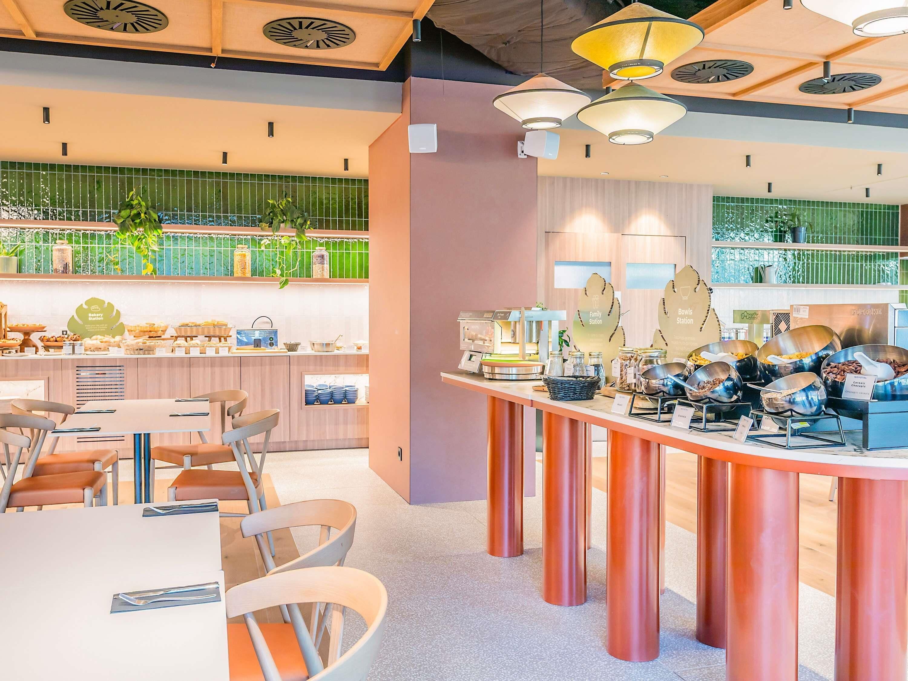 A modern cafe with a counter displaying various baked goods and a buffet area with food containers.