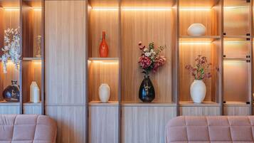 A modern interior with wooden paneling, shelves with decorative vases, and cushioned seating.