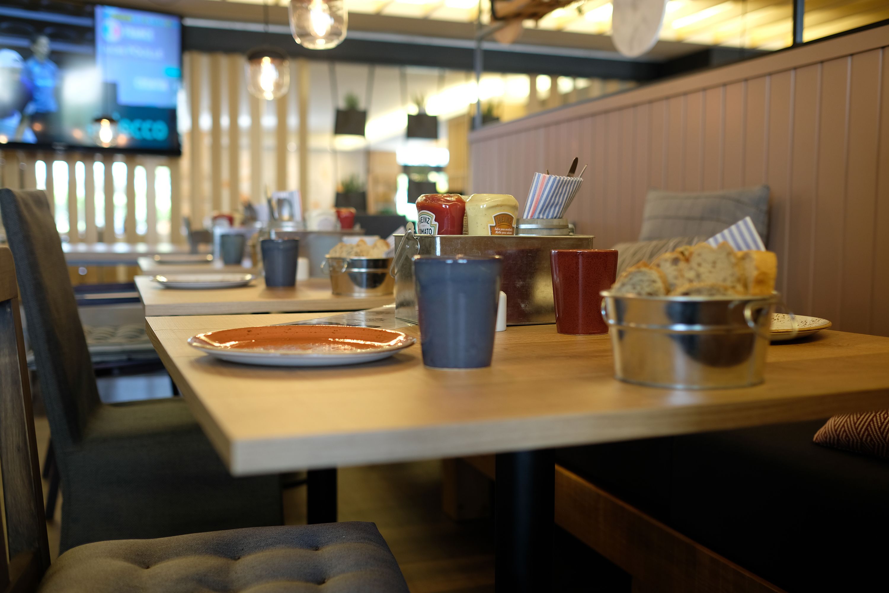 Een restaurantinterieur met tafels, stoelen en diverse gerechten.