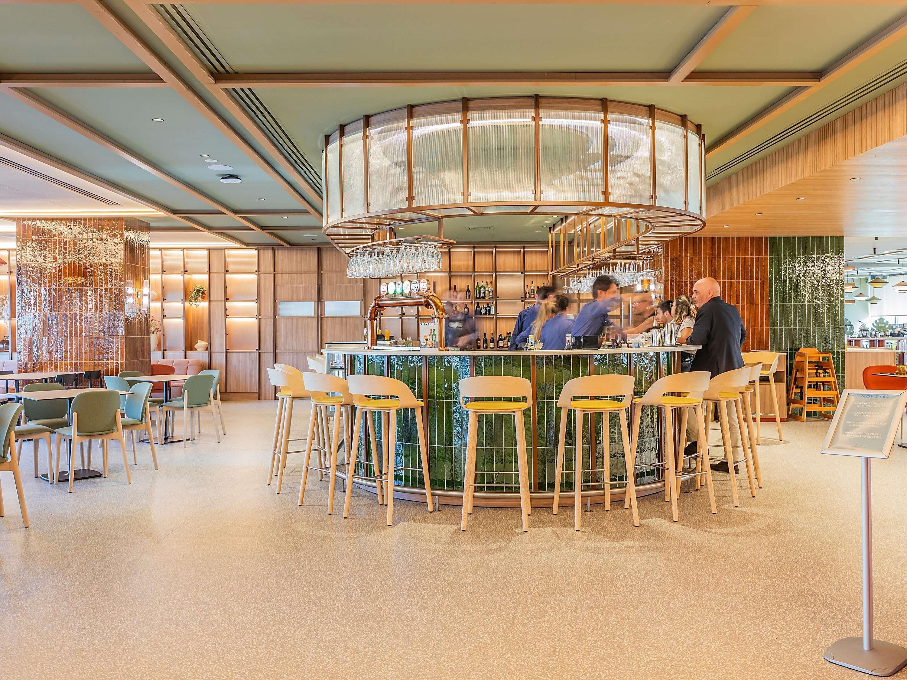 A bar area with stools, a bar counter, and a circular bar design.