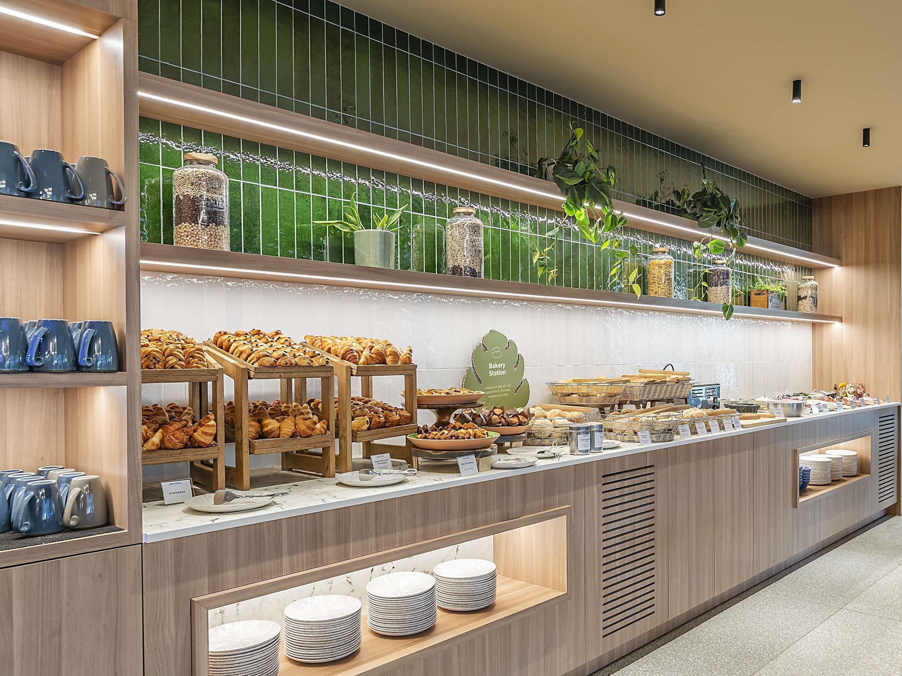 A bakery station with pastries, coffee mugs, and a sign indicating it's a bakery.