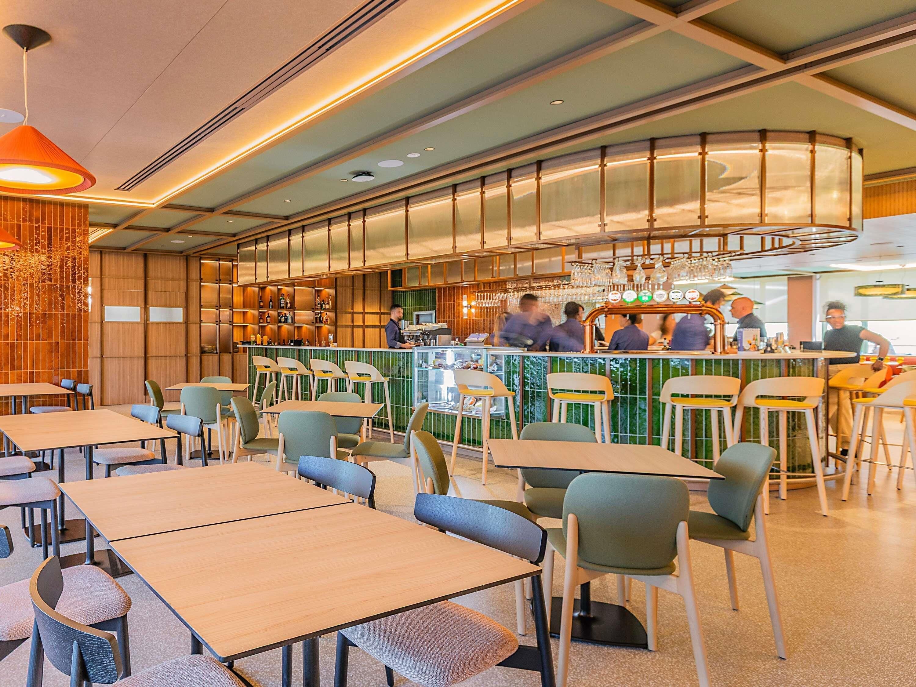 Ein Restaurantinneres mit Barbereich, Sitzgelegenheiten und modernem Design.