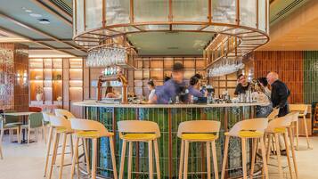 A bar area with a circular bar counter, stools, and a decorative ceiling.