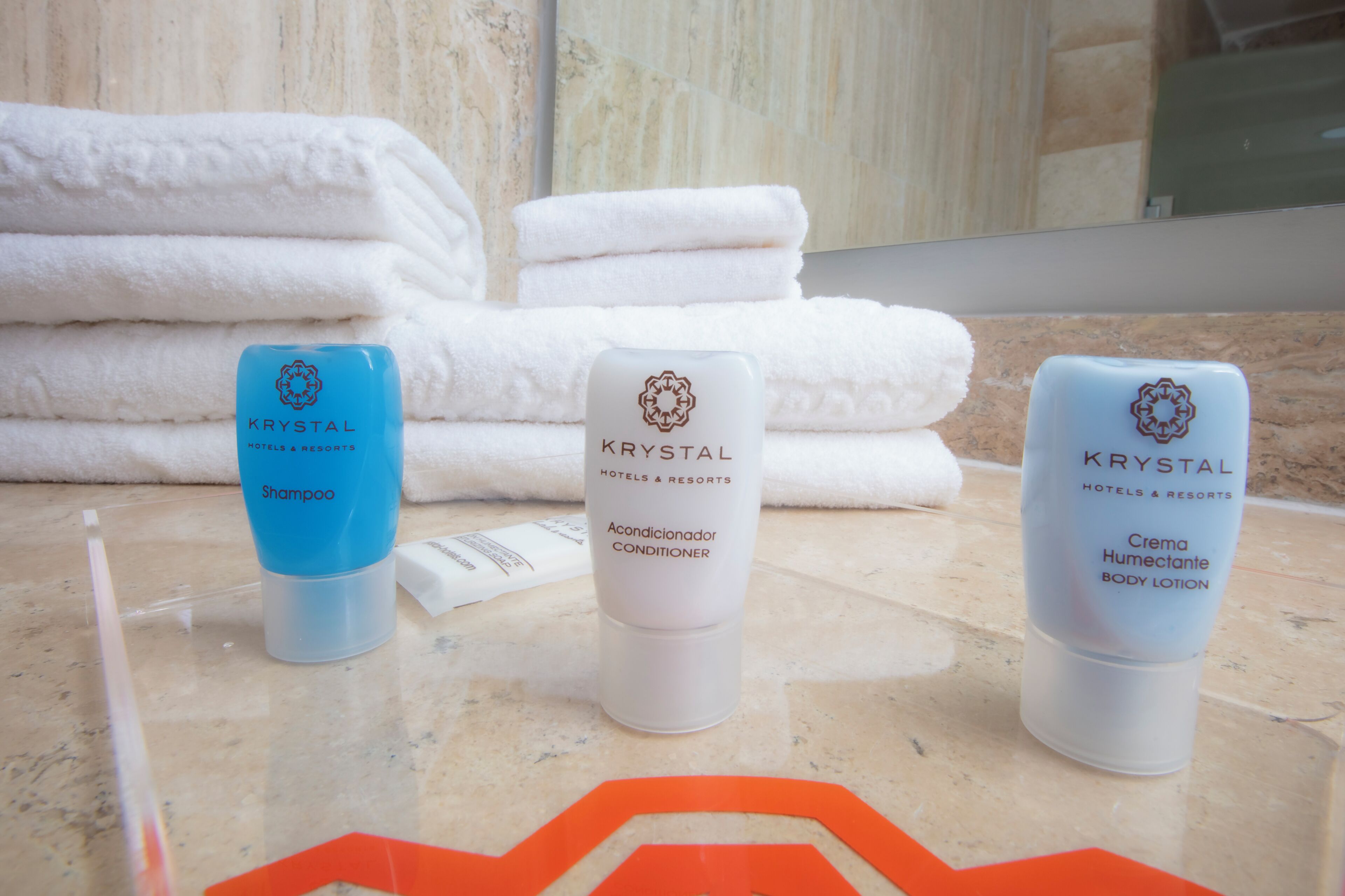 Trois flacons de produits d’hôtel et de centre de villégiature Krystal : shampoing, après-shampoing et lotion pour le corps.