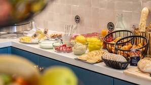 Un buffet proposant une variété d’aliments, notamment des fruits, des fromages et des pains.