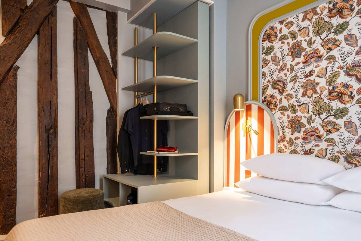 Une chambre à coucher avec un lit, une armoire et une table de chevet.