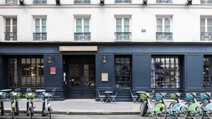Un hôtel à la façade sombre, une enseigne indiquant « HÔTEL Mercure », et une rangée de vélos garés devant.
