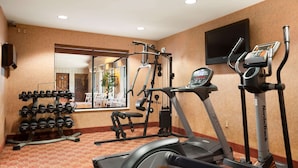 A hotel gym with cardio equipment, weight machines, and a dumbbell rack. - Ramada by Wyndham Wisconsin Dells (Baraboo)
