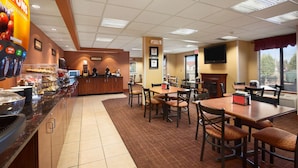A hotel lobby with a self-service beverage station, a reception desk, and a dining area with tables and chairs. - Ramada by Wyndham Wisconsin Dells (Baraboo)