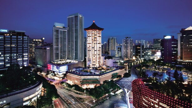 A cityscape at dusk with a prominent tower hotel, high-rise buildings, and a well-lit urban area. - Singapore Marriott Tang Plaza Hotel  (Singapore)
