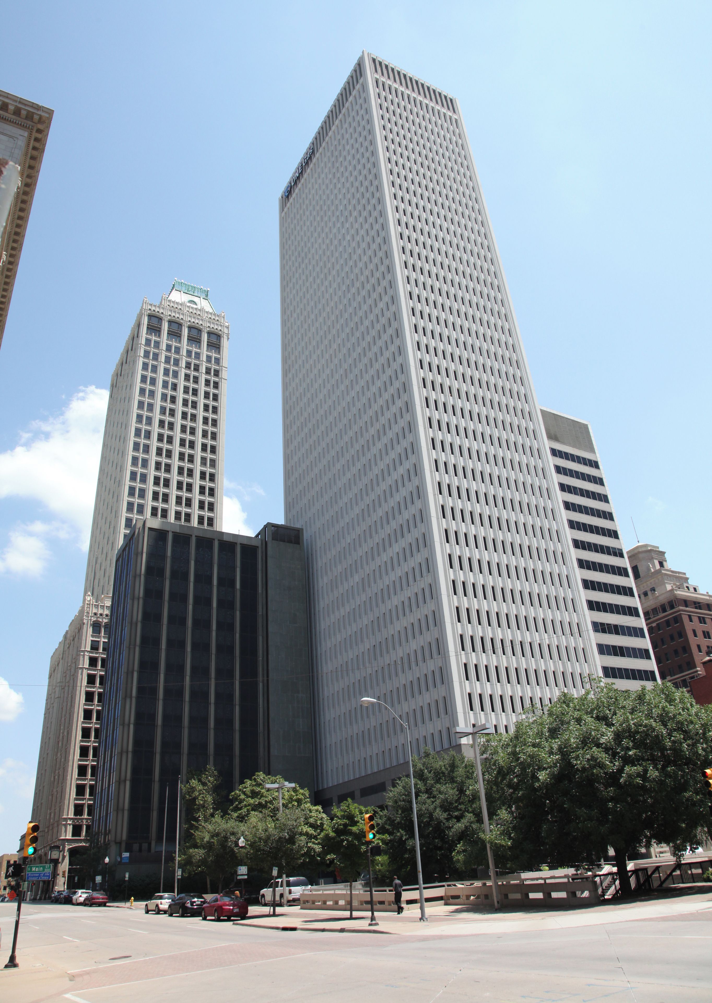 A cityscape with tall buildings, a street intersection, traffic lights, and a pedestrian crossing.