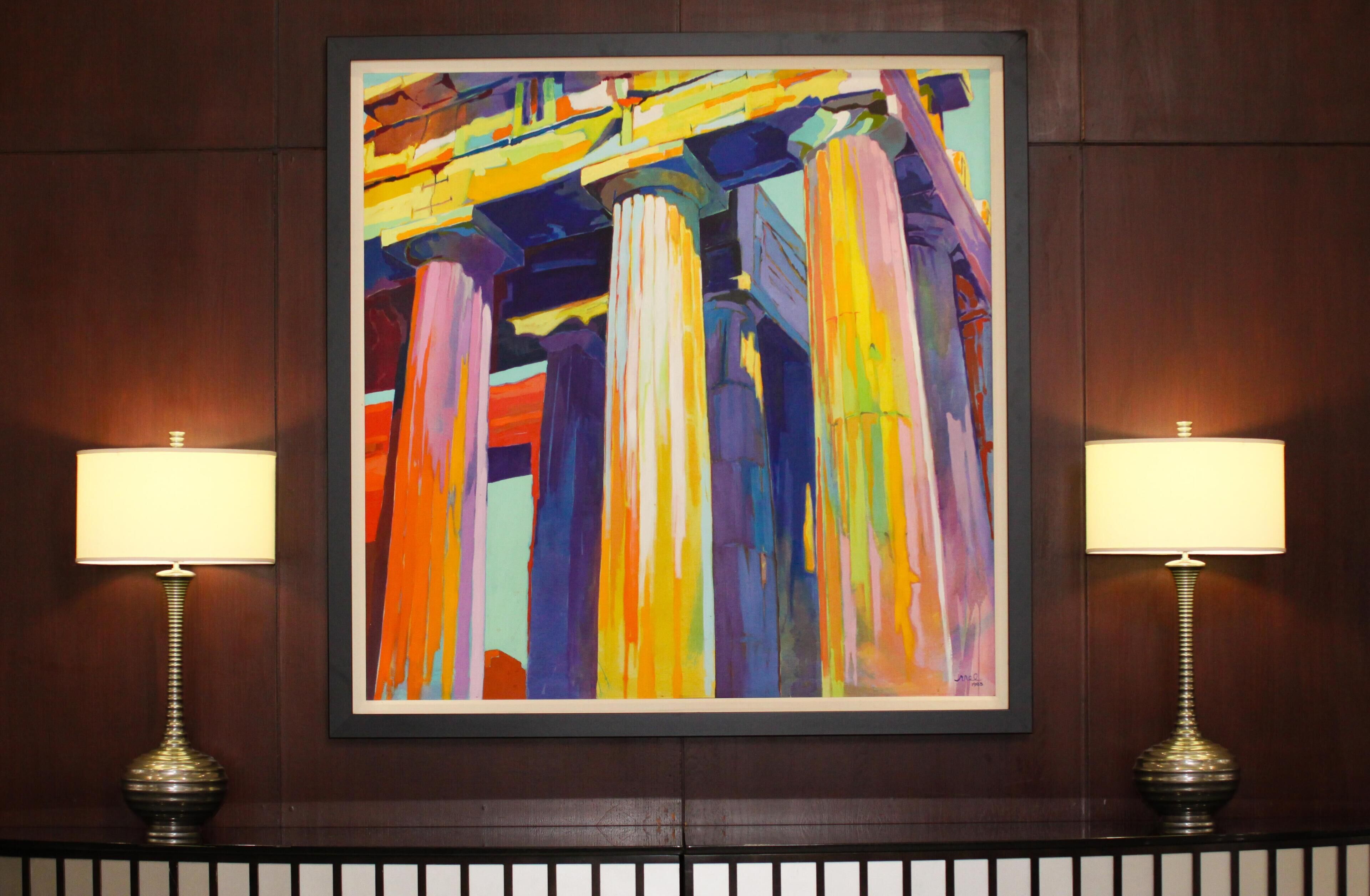 A framed abstract painting with a warm color palette, flanked by two wall-mounted lamps.