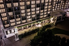 A hotel with a modern facade, multiple balconies, and a ground-level restaurant area.