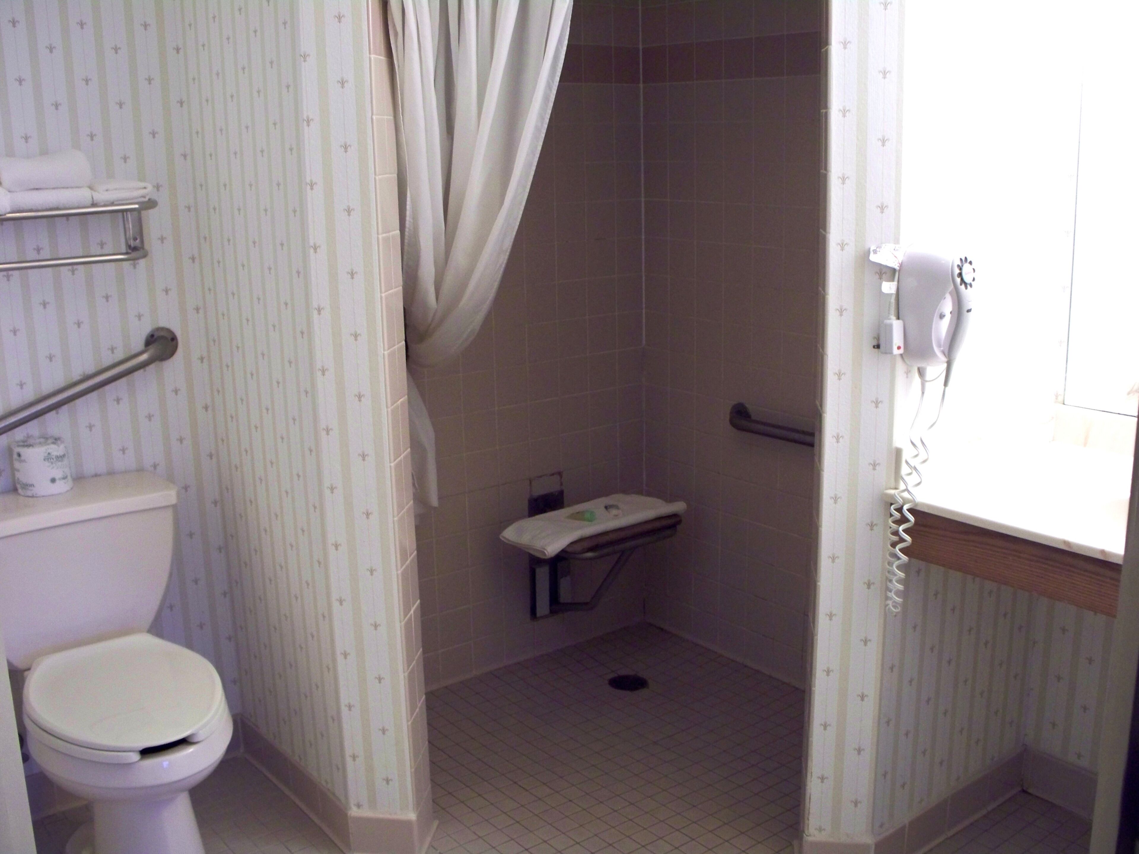 Un baño pequeño con inodoro, cabina de ducha y teléfono.