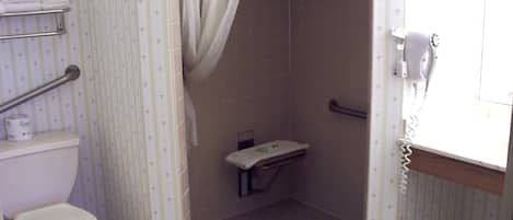 Un baño pequeño con inodoro, cabina de ducha y teléfono.