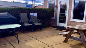 A patio with a table, chairs, and a wooden bench. - Country Inn Deerwood (Deerwood)