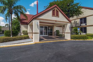 A building with a red roof, a covered entrance, and a sign indicating the number 25. - Red Roof Inn & Suites Brunswick I-95 (Brunswick)