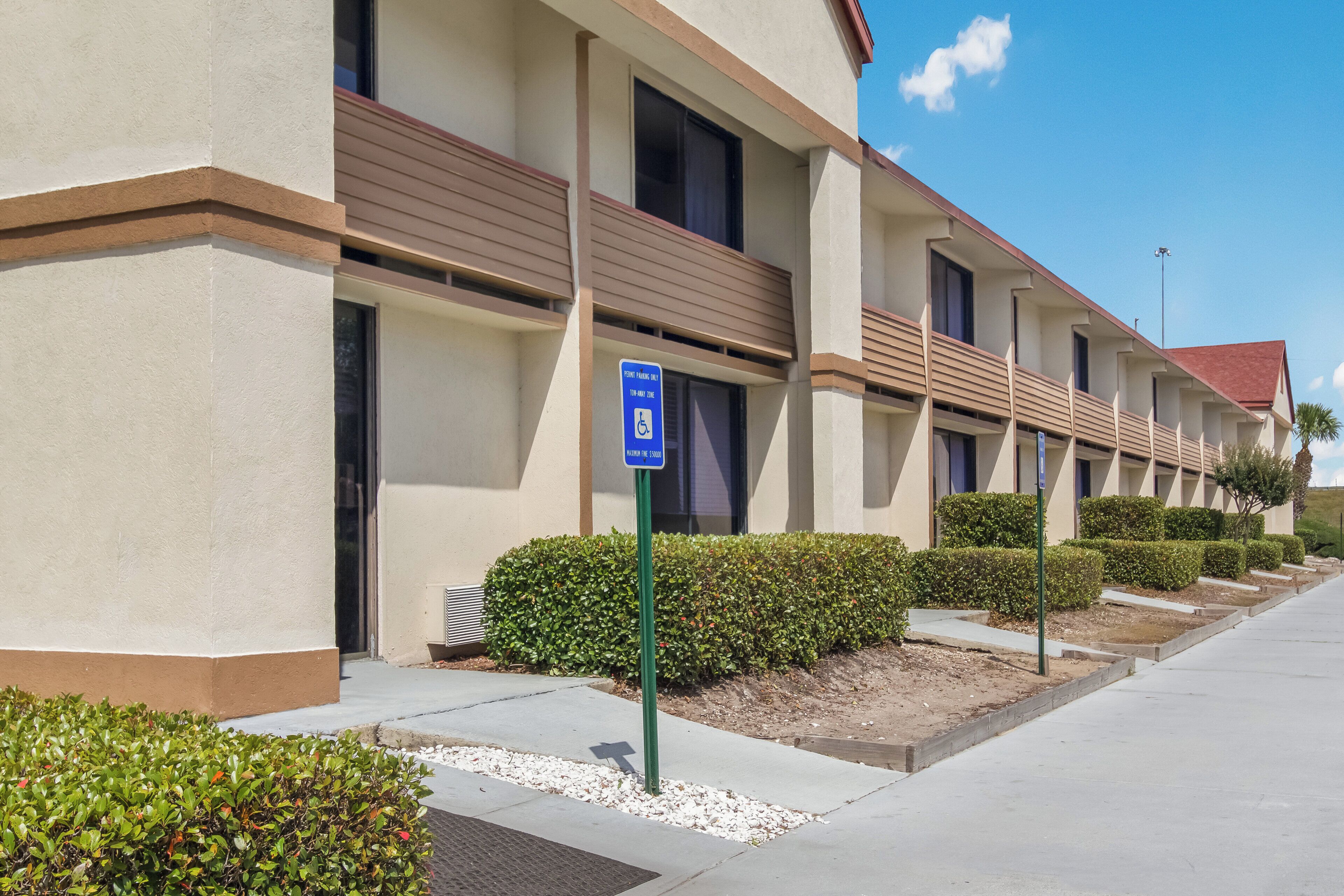 A hotel with a parking sign indicating a disabled parking zone.