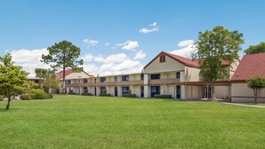 A multi-story hotel with a flat roof and a well-maintained lawn in the foreground. - Red Roof Inn & Suites Brunswick I-95 (Brunswick)