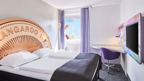 Une chambre d’hôtel avec un lit, un bureau, une chaise et un téléviseur.
