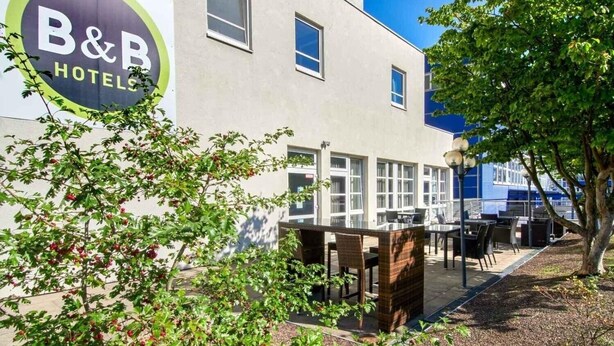 Un hôtel-chambre d’hôtes doté d’un patio avec coin salon extérieur et d’une grande fenêtre donnant sur le jardin.